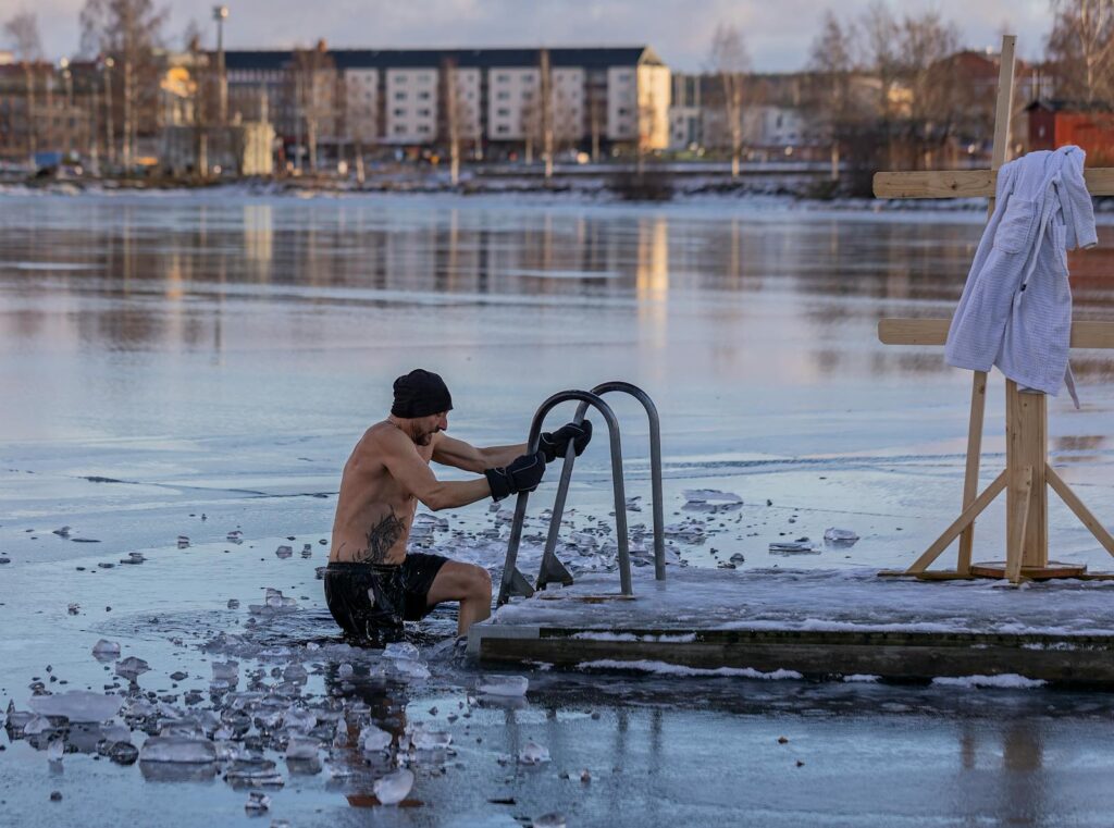 Shirtless man in freezing lake near Ludvika, Sweden, captured during a winter swim. Sublime ice scenery.